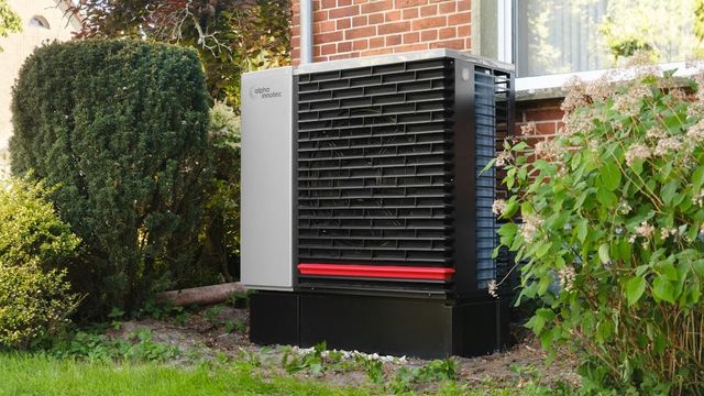 An outdoor standby generator unit installed next to a brick building.