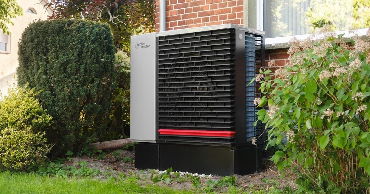 An outdoor standby generator unit installed next to a brick building.