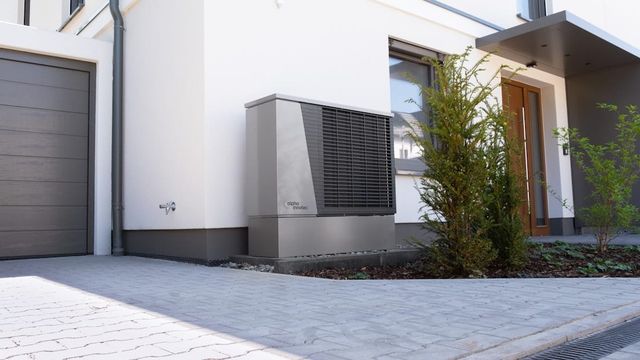 A modern house with an outdoor backup power unit installed alongside it.