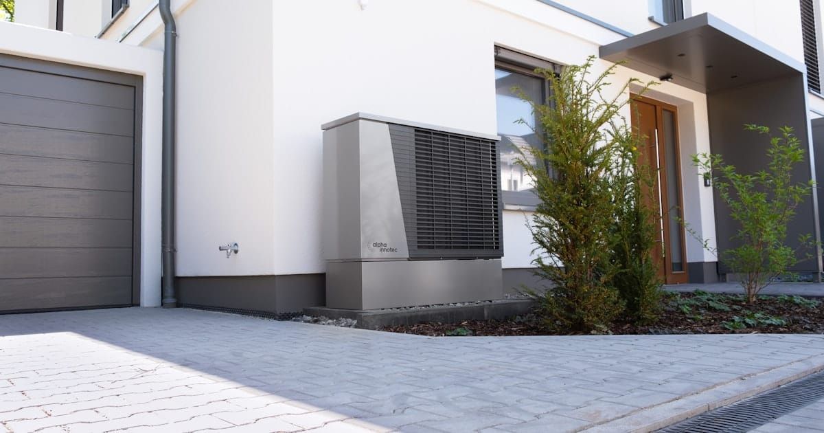 A modern house with an outdoor backup power unit installed alongside it.