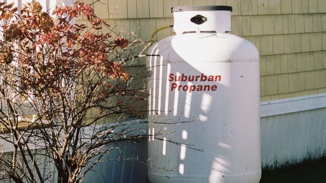 A white backup power unit sited next to a house.